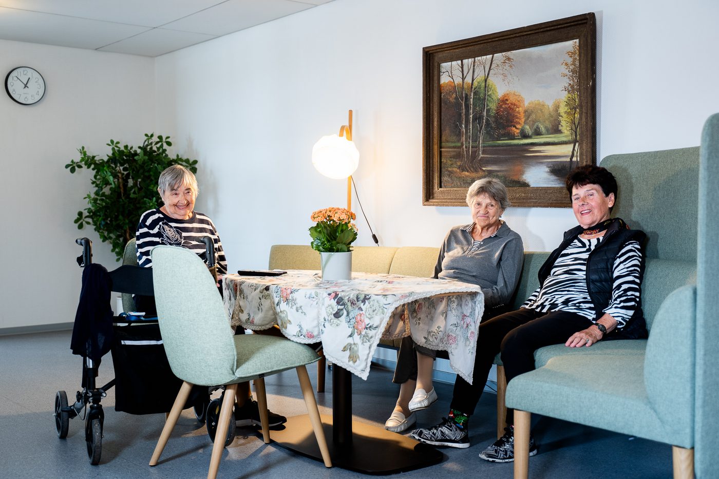 Drei Bewohnerinnen sitzen zusammen in einer Sitzgruppe im Haus